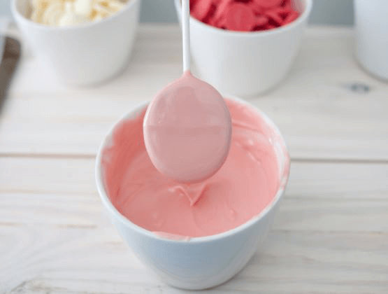 Pink candy melts in bowl with spoon