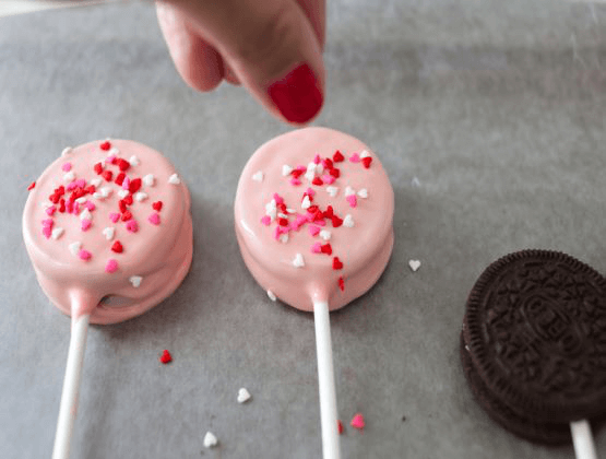 Dipped Oreo pops with sprinkles on lined tray