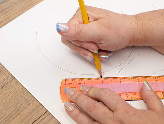 P-touch Embellish Craft Step 2 person using a ruler to draw lines on the paper 