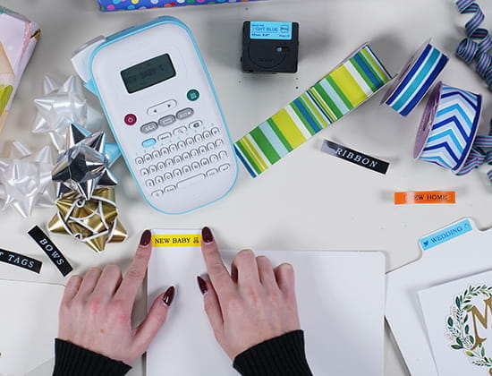 Brother Ptouch with Label Tape and Gift wrapping equipment around, a person labeling a folder