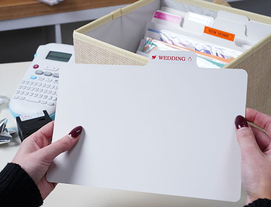 Person Holding a Folder with a Brother Ptouch label on top