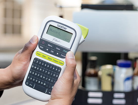 Hand Holding P-touch close to grilling station outside