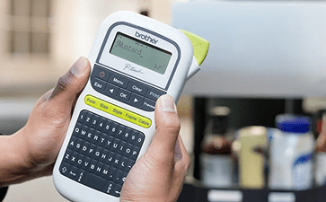 Hand Holding P-touch close to grilling station outside