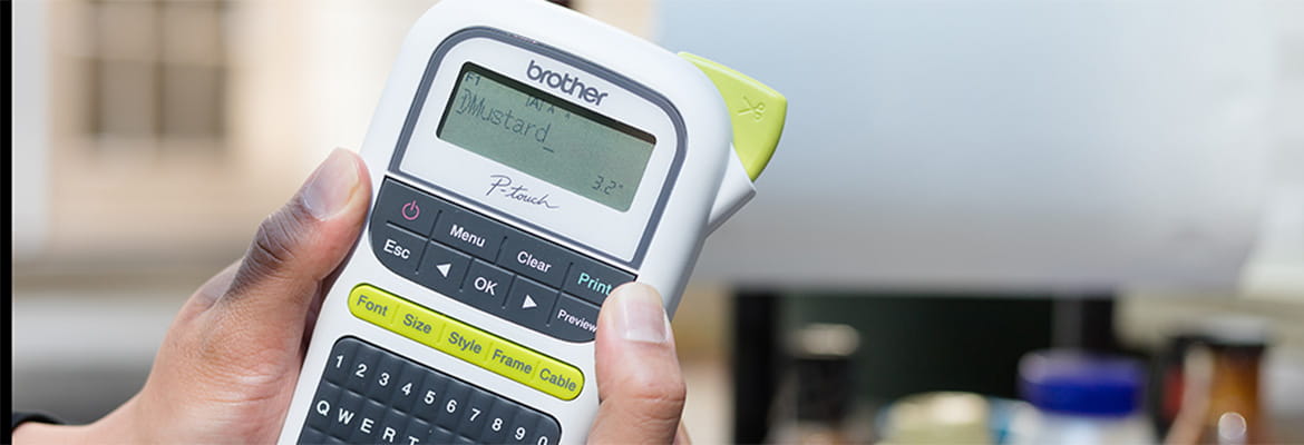 Hand Holding P-touch close to grilling station outside