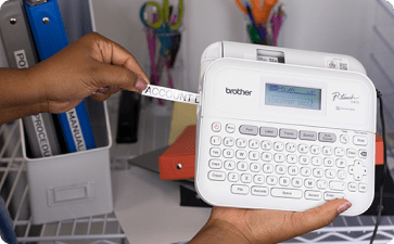 Brother Label Maker printing a Label for Binder, Hand holding the Label