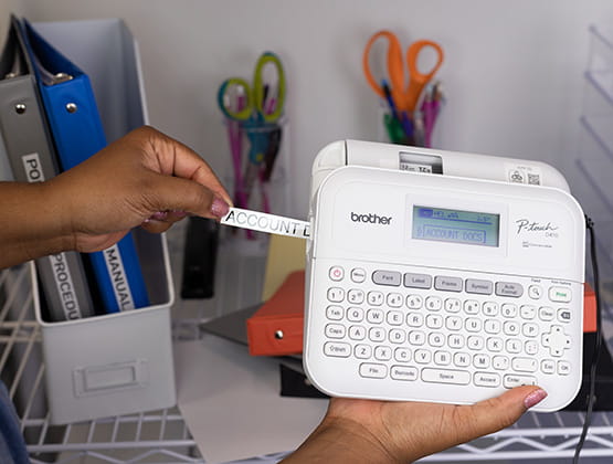 Brother Label Maker printing a Label for Binder, Hand holding the Label