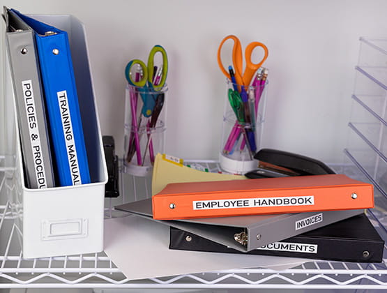 Binders on desk with Labels printed with Brother Label Maker, other tools in the background