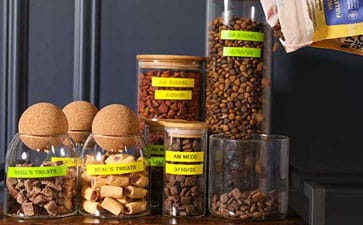 Pet food jars labeled with yellow and green Ptouch Btag labels. 