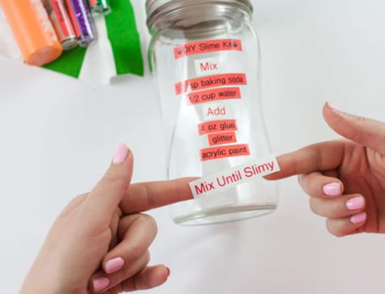 Step 3 - person affixing label tapes to glass jar
