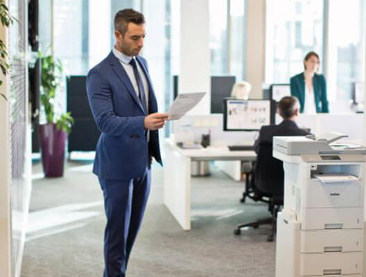 Man in blue suit examines printed paper