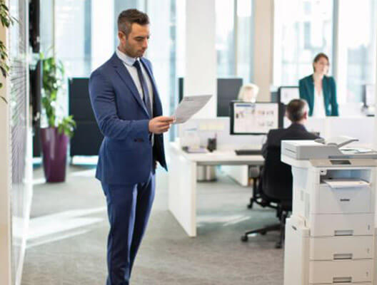 Man in blue suit examines printed paper