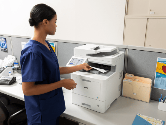 Woman Picking up Paper from Brother Printer