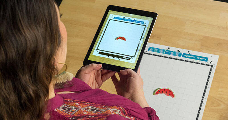 Woman holding tablet using ScanNCutCanvas cloud app
