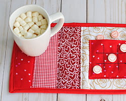 Hot chocolate on a mug on a quilted mat.