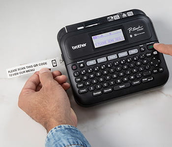 Person using PT-D460BT label maker to print a label