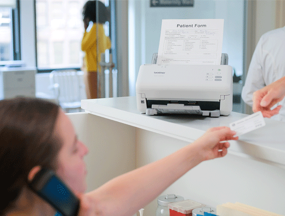 Medical associate helping patient with ADS-4300N on counter