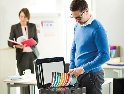 Man in blue sweater uses a Brother scanner