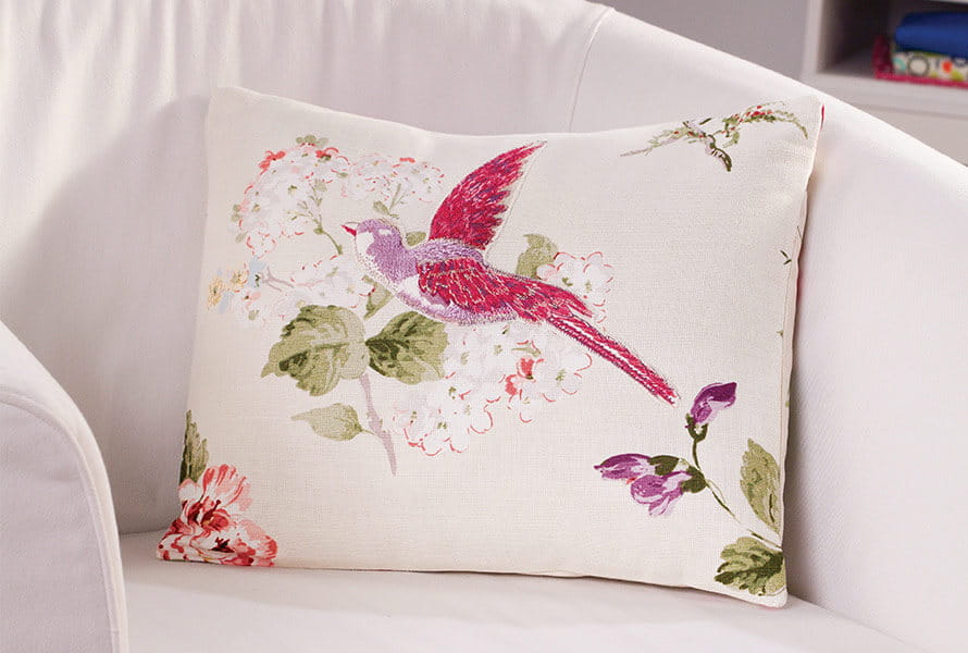 White arm pillow with pink bird and floral patterns