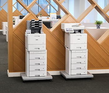 HL-L9470 and MFC-L9670 Brother enterprise laser printers against a wall 