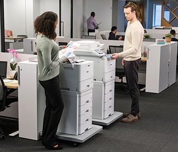Coworkers printing on HL-L9470 and MFC-L9670 enterprise laser printers in an office