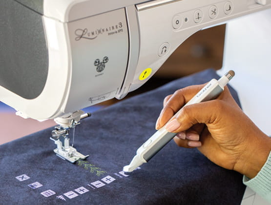 Person using stylus in work area with StitchVision feature