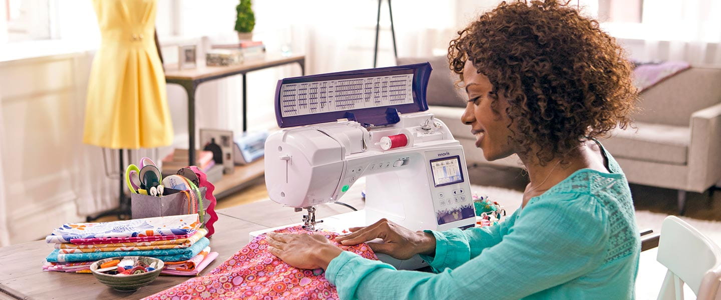 Woman using NQ3500D sewing machine and working on table at home