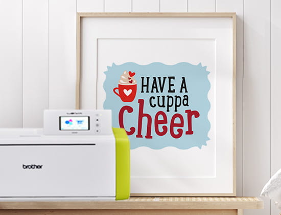 Brother ScanNCut next to framed design with "Have a cuppa cheer" text