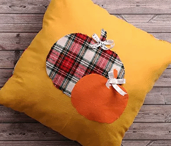 Yellow pillow with plain and orange pumpkins
