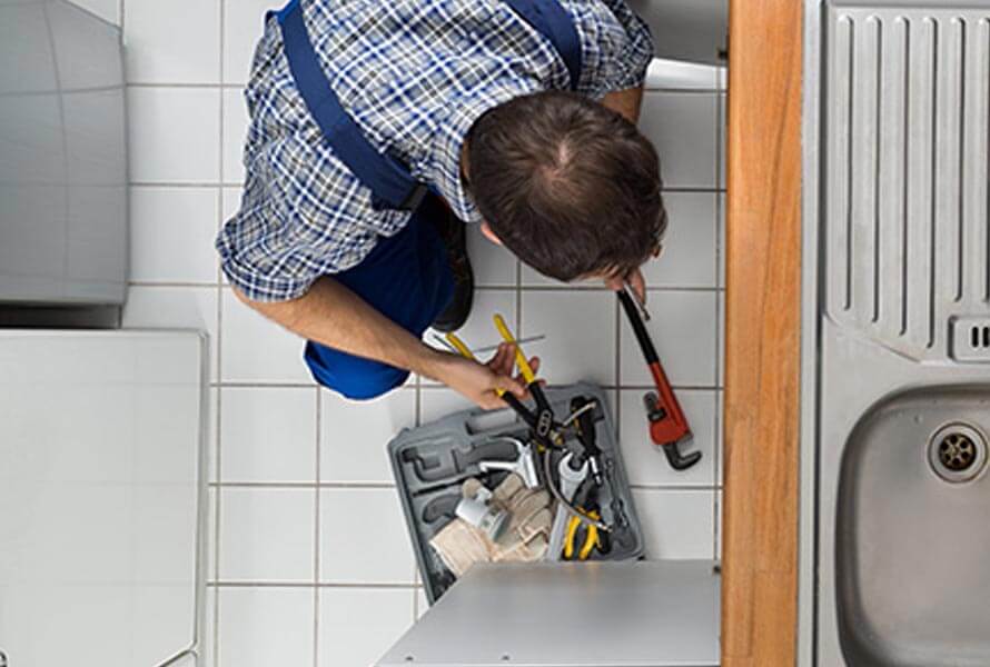 Overview of man performing plumbing work