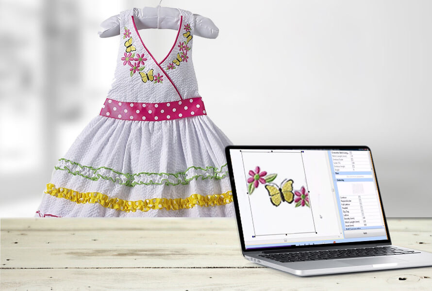 Monogrammed dress next to laptop showing the design template