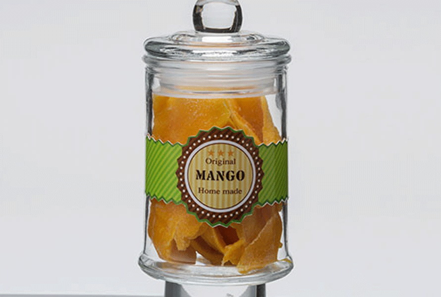 Custom "Mango" label on a clear glass jar containing dried mangos