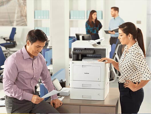 Man and woman in office with Brother printer